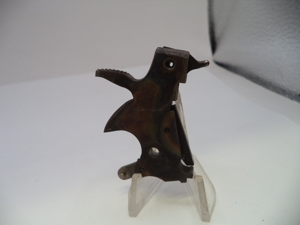A small dark metal bird-shaped object displayed on a clear plastic stand against a plain light background.