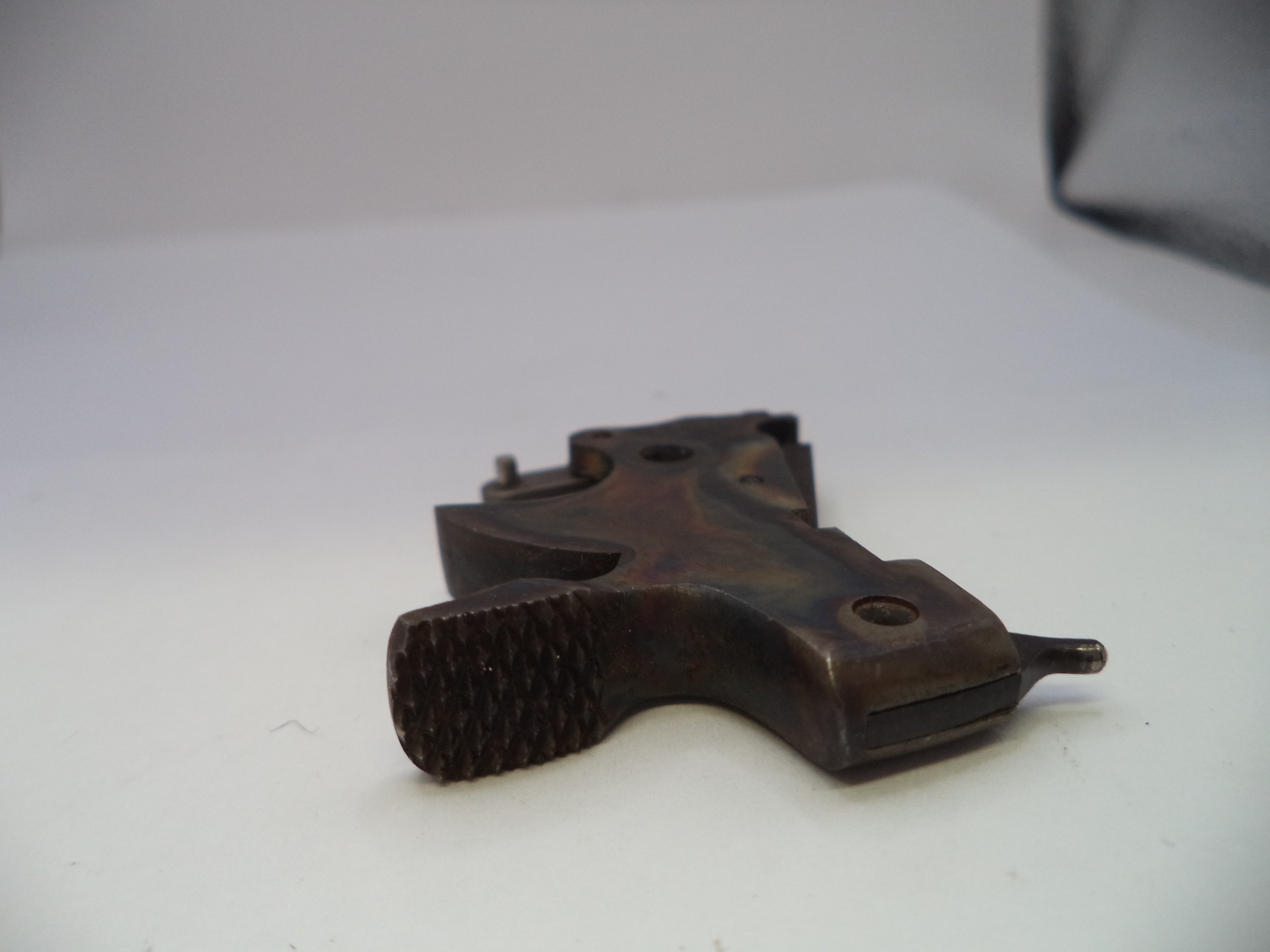 A dark brown textured metal gun grip replacement part, photographed on a plain white background.
