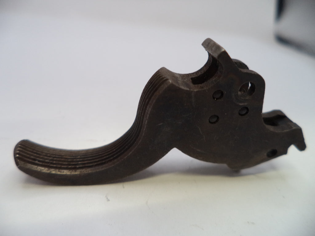 A dark metal firearm trigger assembly, likely a striker or release lever, photographed on a plain white surface.
