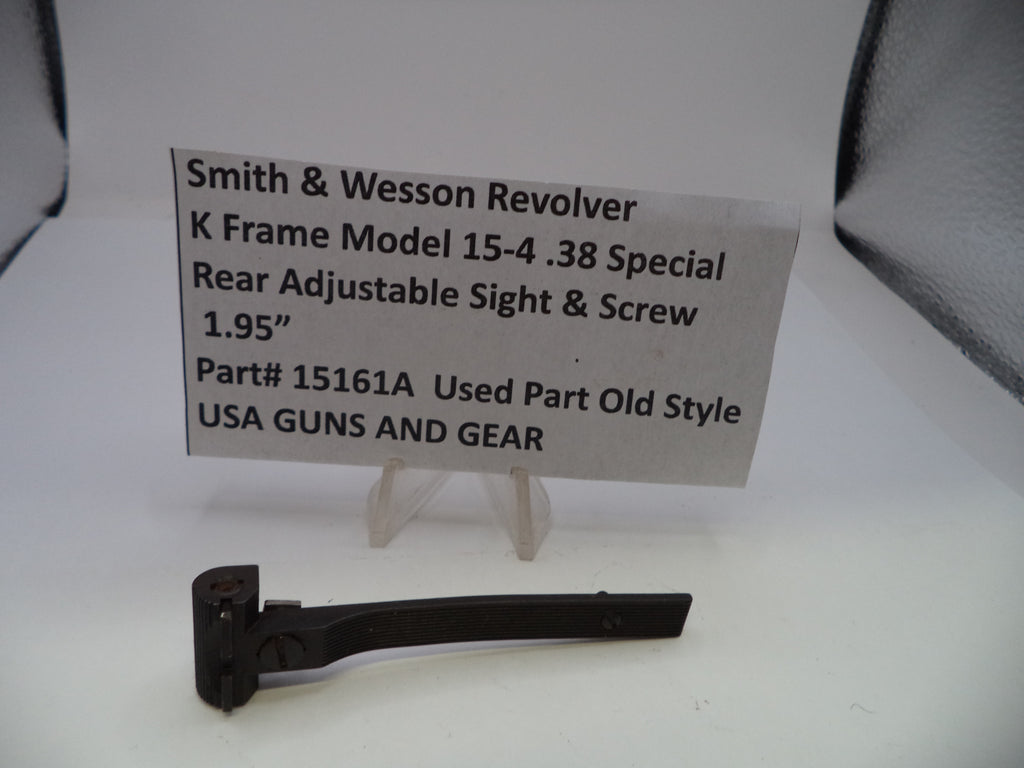 A black metal Smith & Wesson revolver rear adjustable sight and screw part on a white surface, with a paper label card displaying part number 15161A and product details.