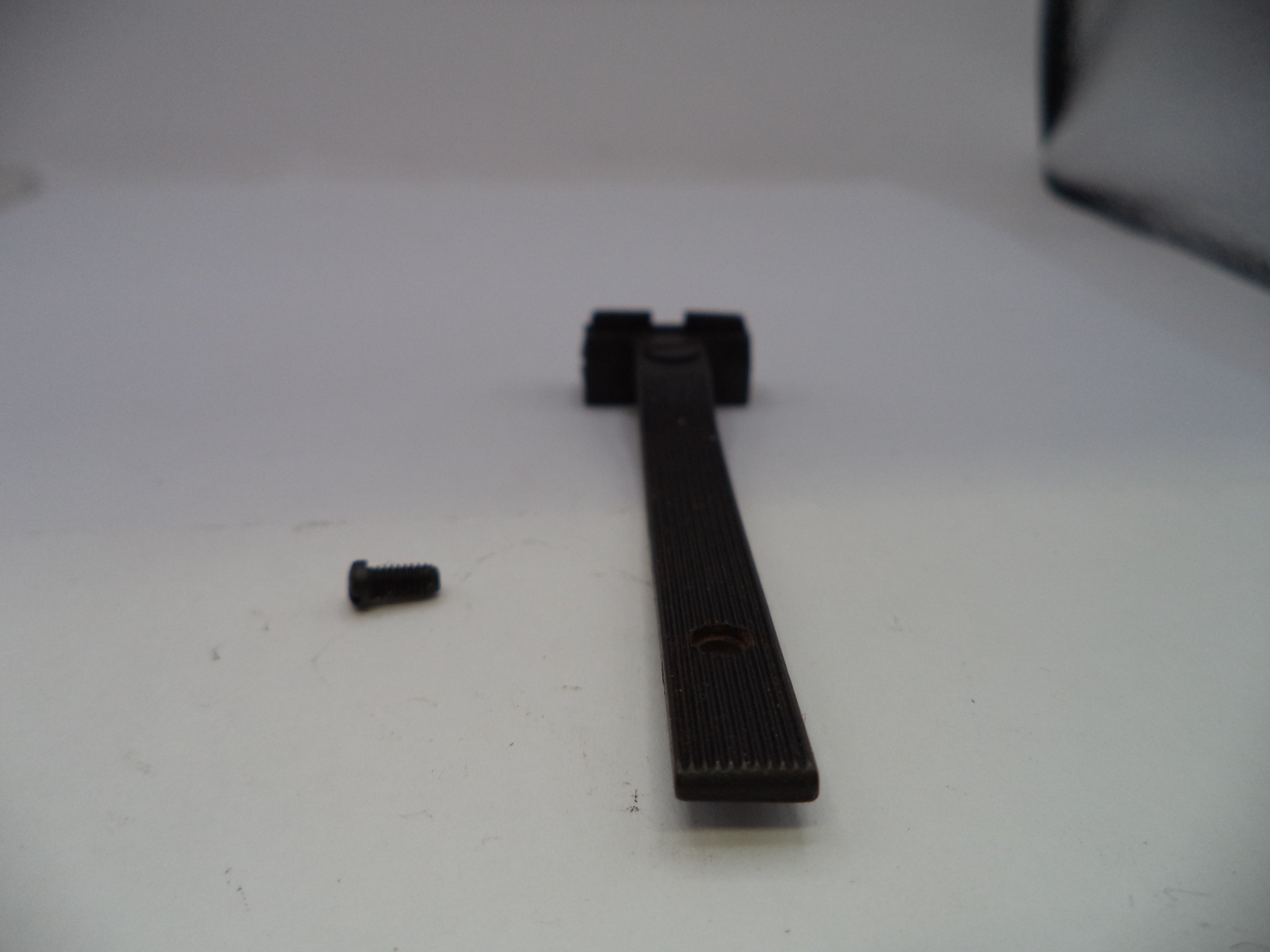 A black textured replacement handle or lever with a small black screw, shown on a plain white surface.