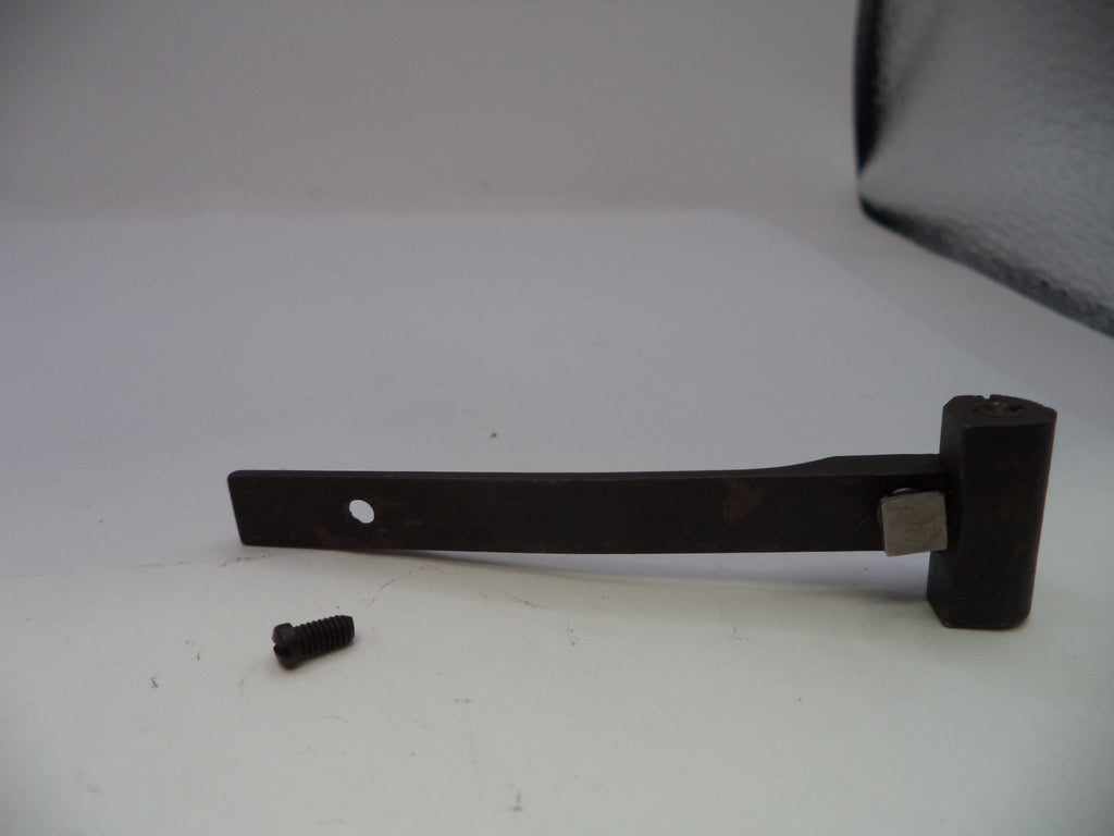A dark metal lever or bracket with a small screw fastener placed beside it on a plain white surface.