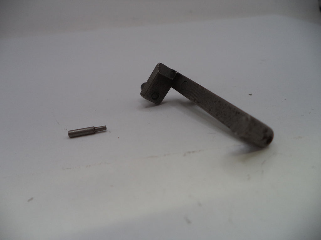 A small metal mechanical part, possibly a bracket or pin assembly, shown on a plain light gray surface.