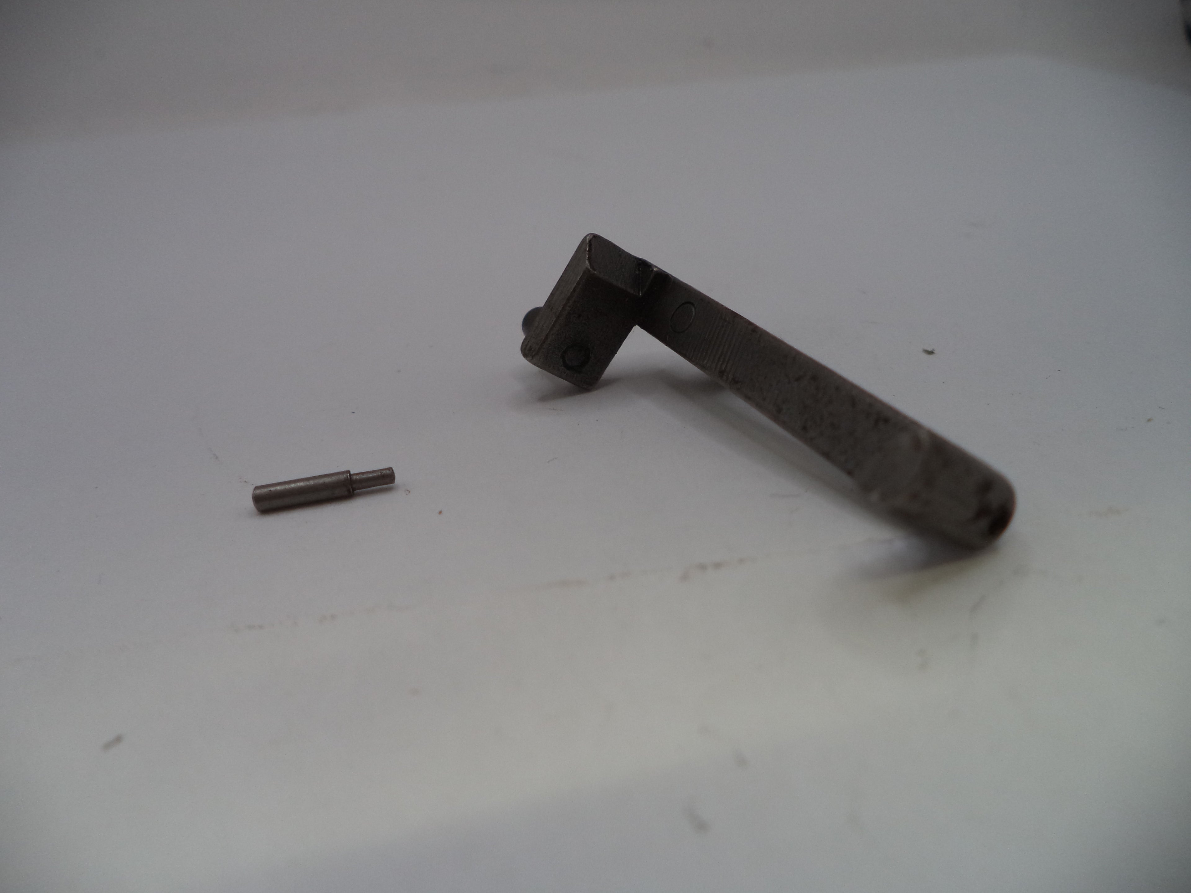 A small metal mechanical part, possibly a bracket or pin assembly, shown on a plain light gray surface.