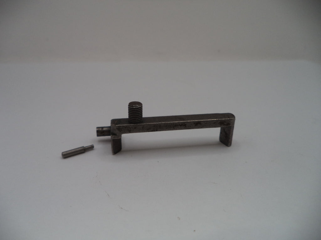 A dark metal mechanical tool or hardware piece with a threaded screw post and a small separate pin, photographed on a plain light background.