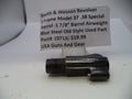 A black metal Smith & Wesson revolver barrel airweight part, shown on a white surface with a paper label card in the background.