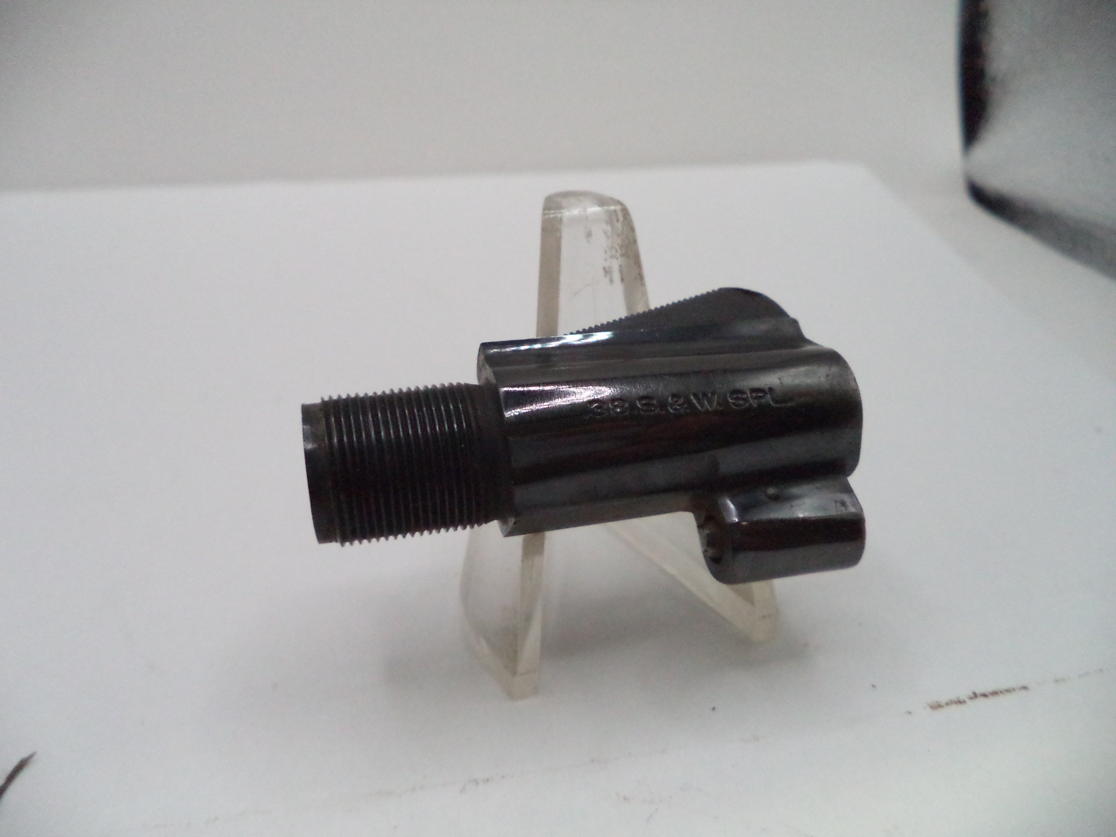 A black metal threaded component, likely a faucet or fixture part, displayed on a clear plastic stand against a white background.