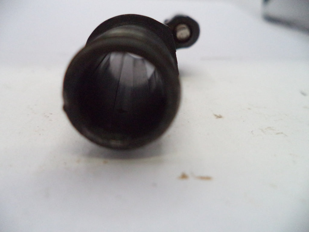 A close-up shot of a black plastic cylindrical component, possibly a lens or filter, lying on a white surface.