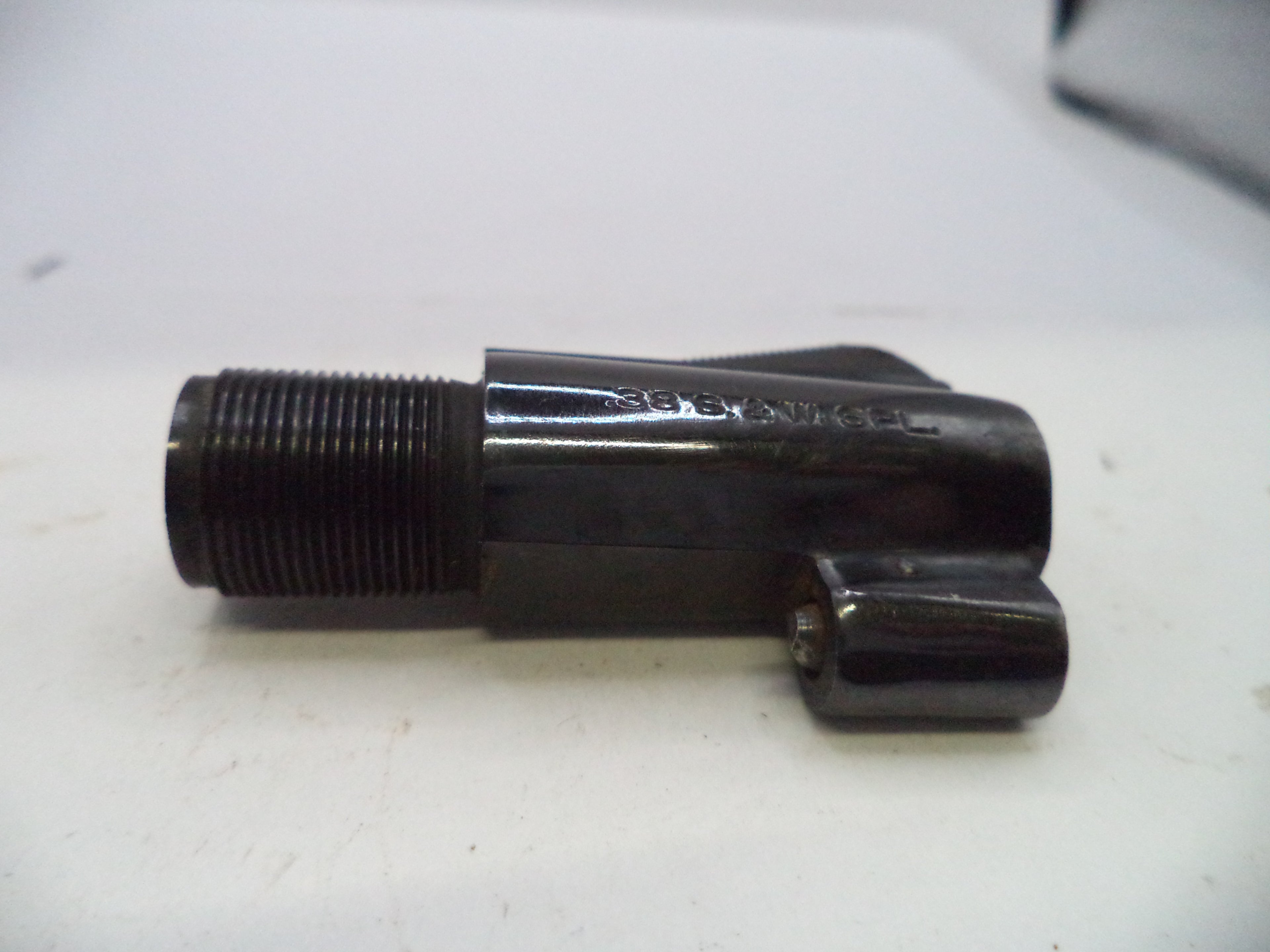 A black metal faucet shutoff valve with a threaded male connection on one end and a lever handle on the other, resting on a white surface.
