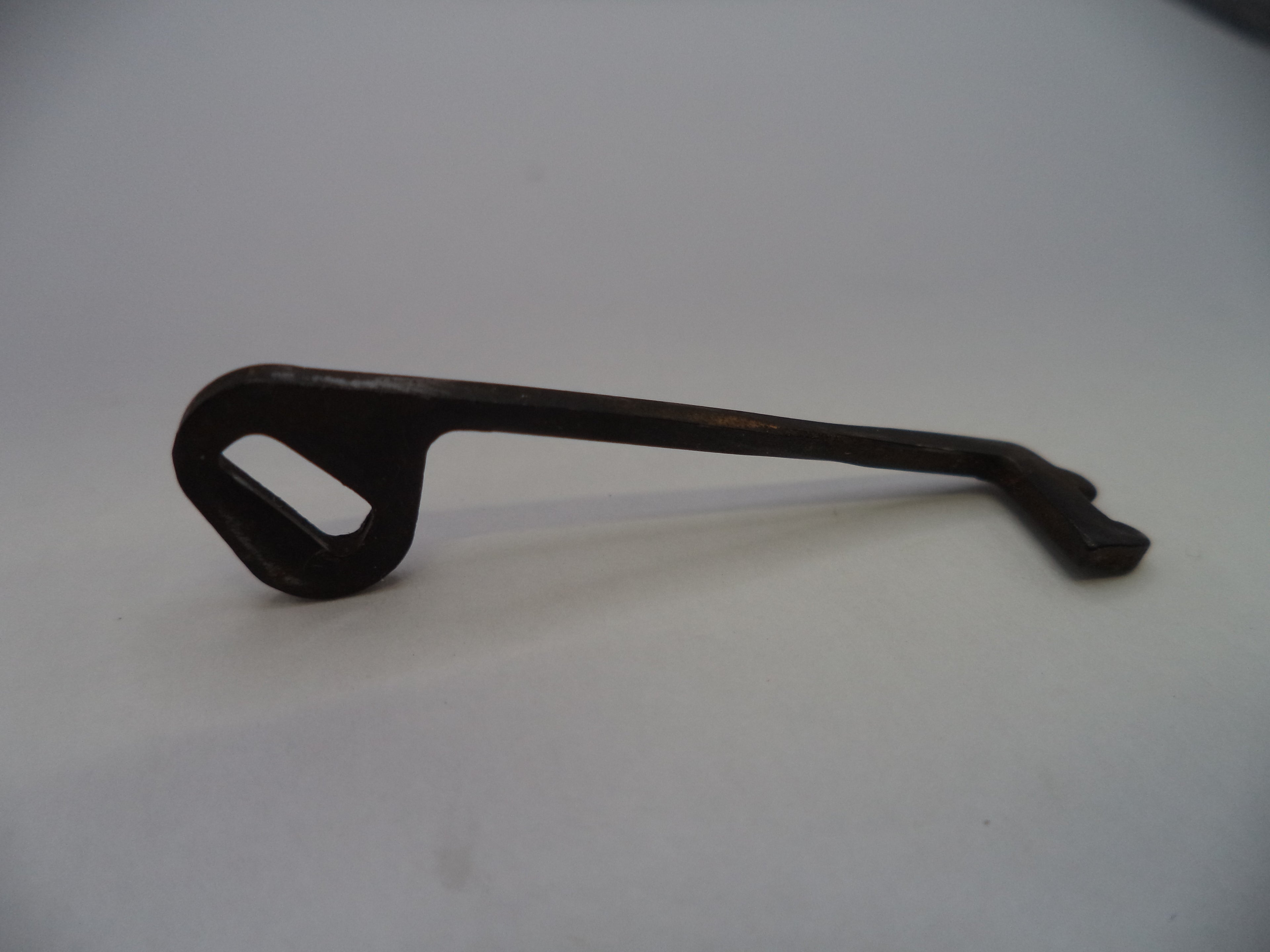 A dark metal door pull handle with a rectangular cutout in the loop, shown on a plain light gray background.