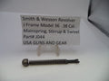 A small metal revolver mainspring part displayed on a white surface with a small sign reading 'Smith & Wesson Revolver J Frame Model 36 .38 Cal.