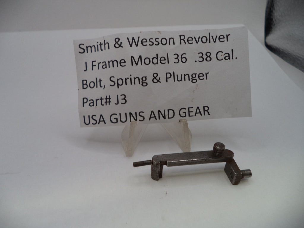 A small metal firearm part displayed on a clear plastic stand in front of a white label card that reads 'Smith & Wesson Revolver J Frame Model 36 .38 Cal.