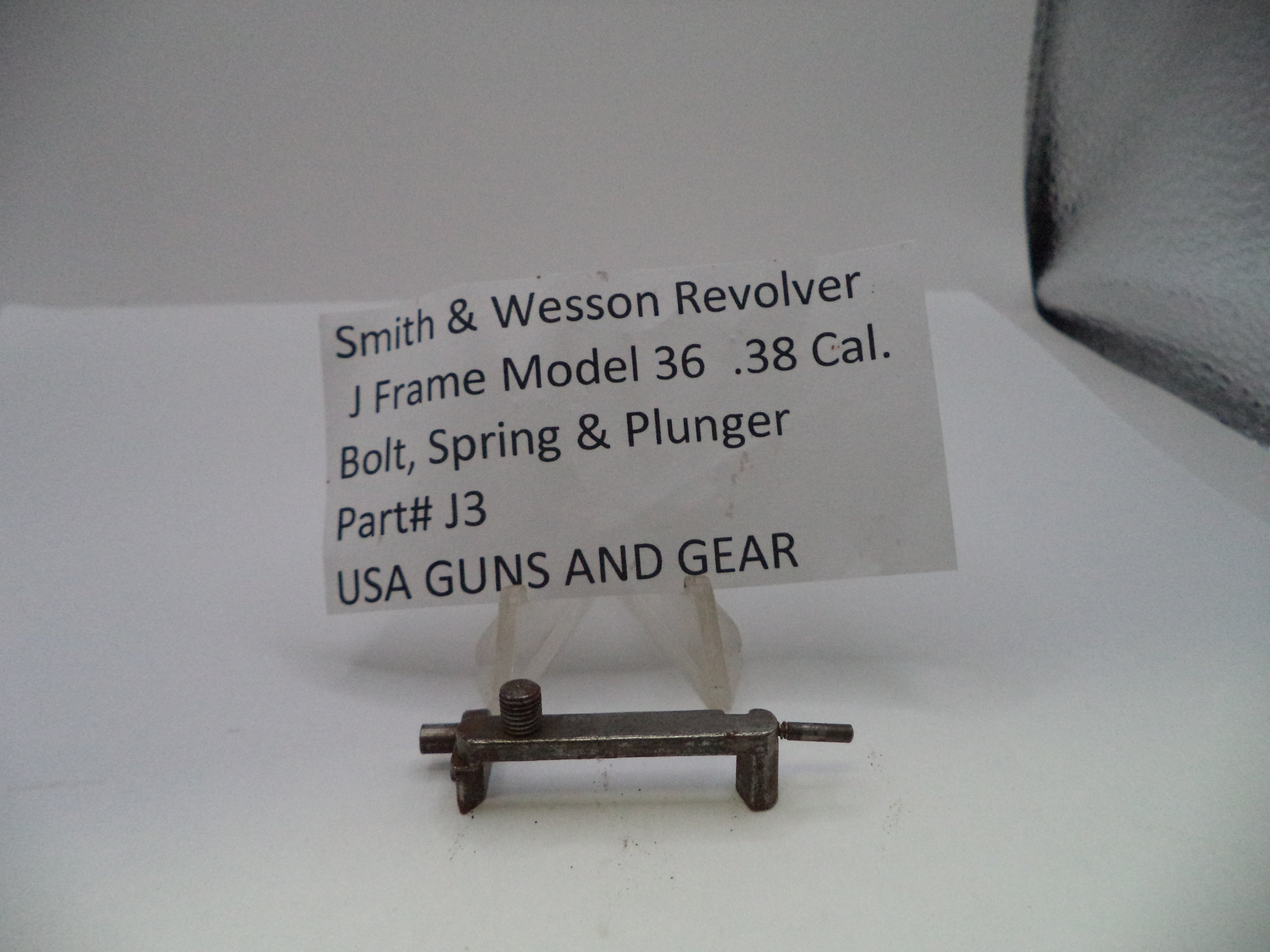 A small metal firearm part labeled 'Smith & Wesson Revolver J Frame Model 36 .38 Cal.