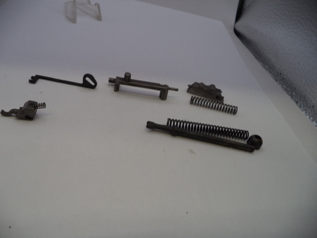 A set of small metal mechanical parts and springs arranged on a plain white surface.