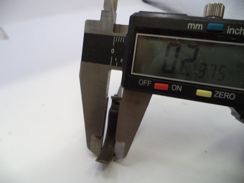 A close-up of a digital caliper measuring a very thin strip, showing a reading of 0.2375 inches (6.