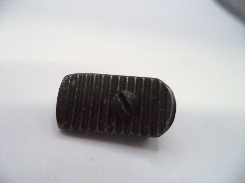 A small dark metal button with a ribbed texture and a central screw head, shown on a plain light background.