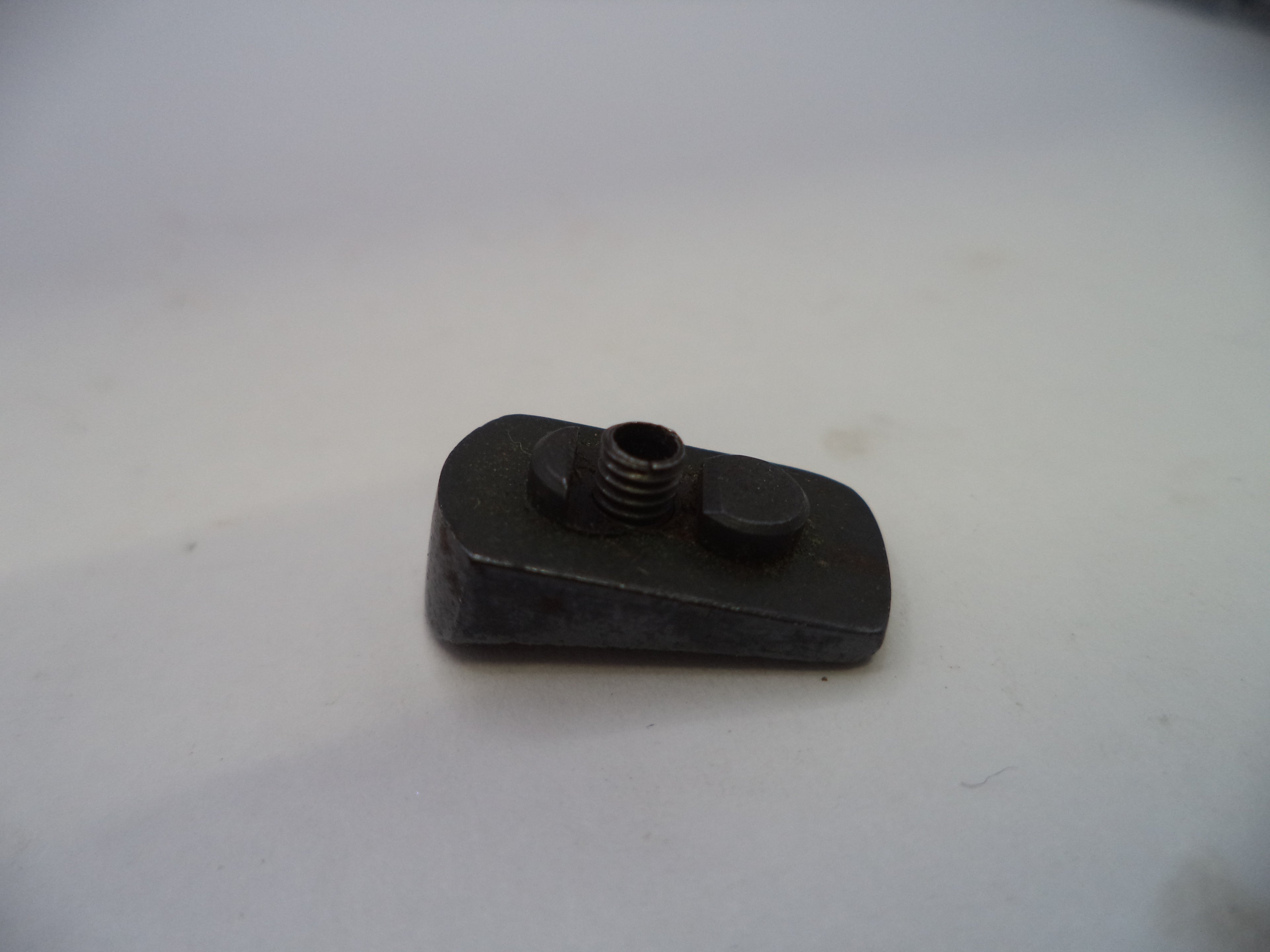 A small black metal mechanical component with a threaded hole and a flat tab, photographed on a plain light background.