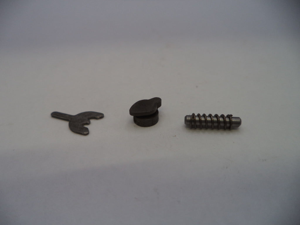 Three small metal hardware components, including a small flat piece, a round black cap, and a threaded screw, arranged on a plain light background.