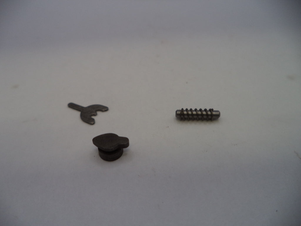 Three small dark metal hardware components, including a small screw, a small flat tab, and a small round knob, arranged on a plain light background.