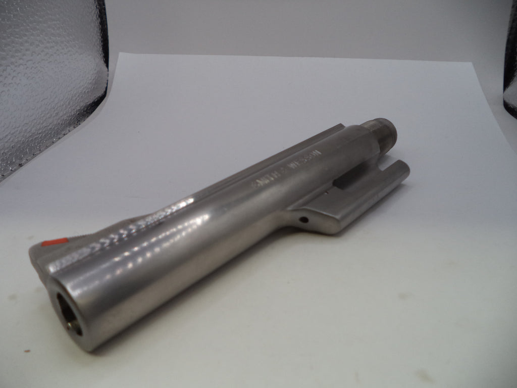 A metallic silver cylindrical tool or component with a textured grip, photographed on a white surface with a softbox visible in the background.
