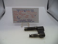 A used black metal revolver cylinder yoke part displayed on a white surface with a handwritten parts identification card behind it.