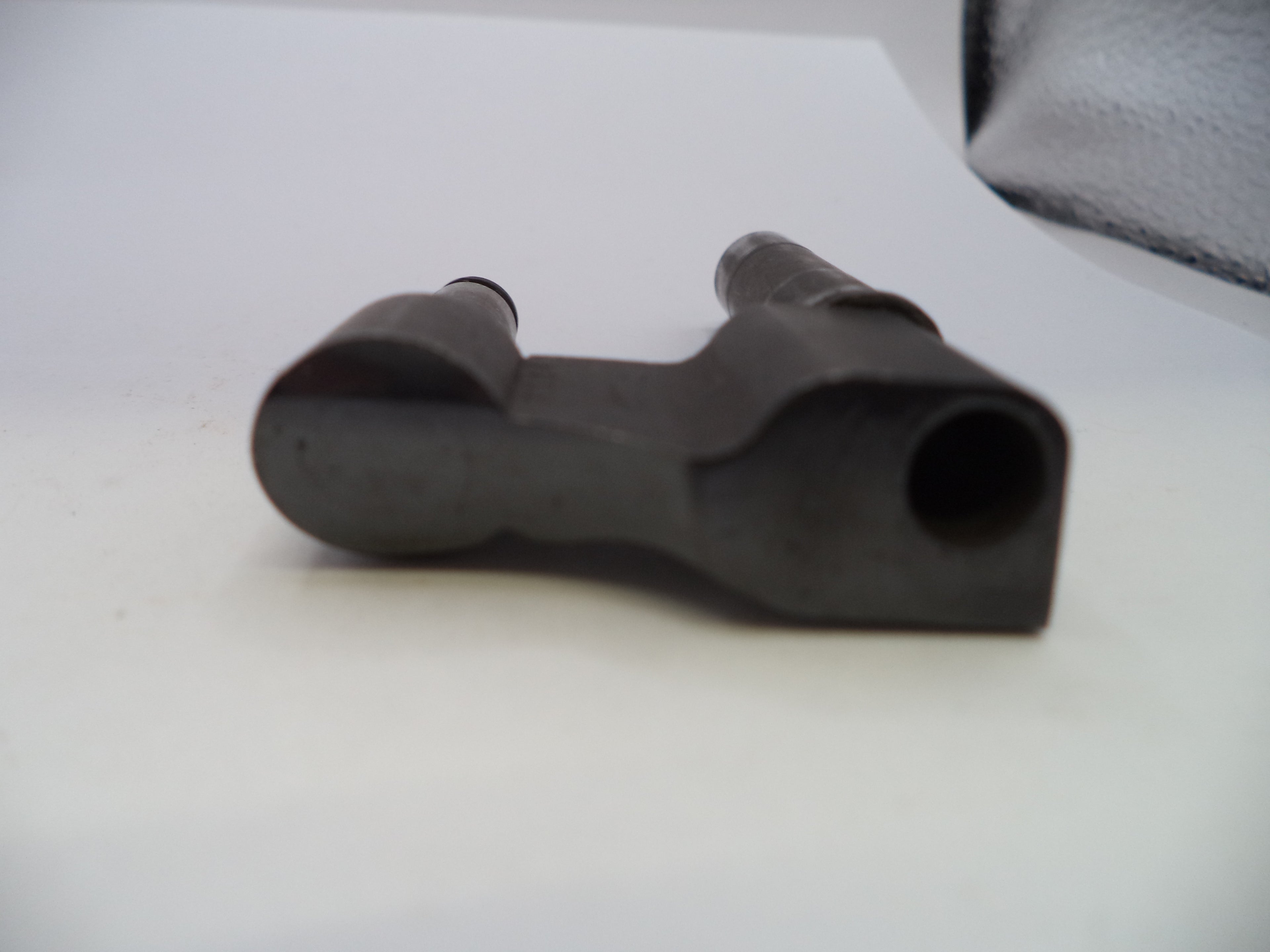 A dark gray cast iron mechanical part, likely a valve stem seat or similar automotive component, shown on a plain white background.