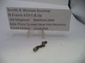 Two small stainless steel side plate screws for a Smith & Wesson revolver, displayed on a white surface with a paper label card behind them.
