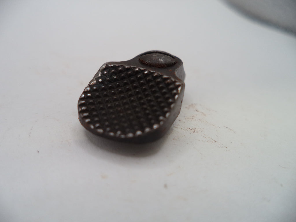 A small dark metal accessory with a textured, dimpled surface and a circular loop at the top, photographed on a plain off-white background.