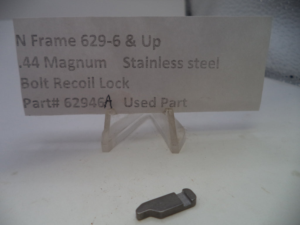A used stainless steel bolt recoil lock for a .44 Magnum N Frame, displayed on a small clear stand next to a paper label card with part number 62946A.