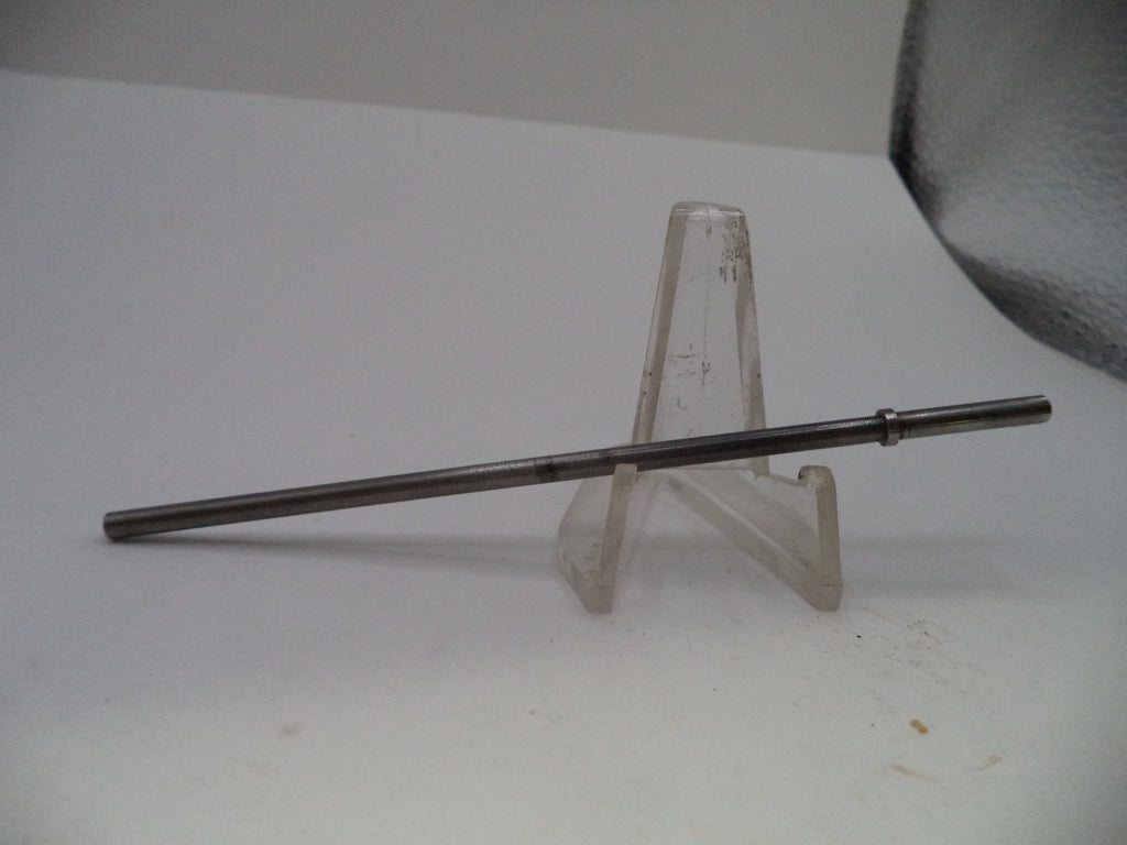 A long, thin metallic rod or pin displayed horizontally on a clear plastic stand against a plain white background.