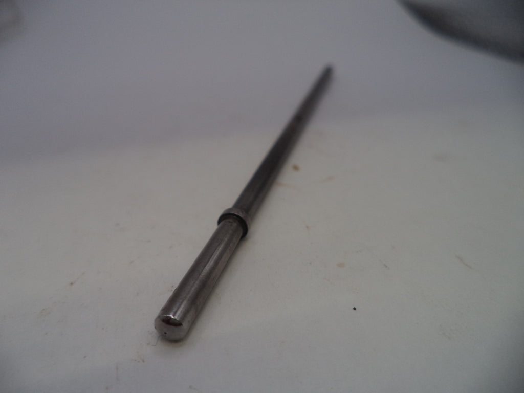 A long, slender metallic rod or shaft with a cylindrical end and a small dark ring near the center, photographed on a plain light surface.