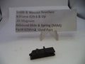 A small black metal revolver rebound slide and spring replacement part displayed on a white surface in front of a clear stand holding a paper label that reads 'Smith & Wesson Revolver N Frame 629-5 & Up .44 Magnum Rebound Slide & Spring (MIM) Part# 629AAQ Used Part'.