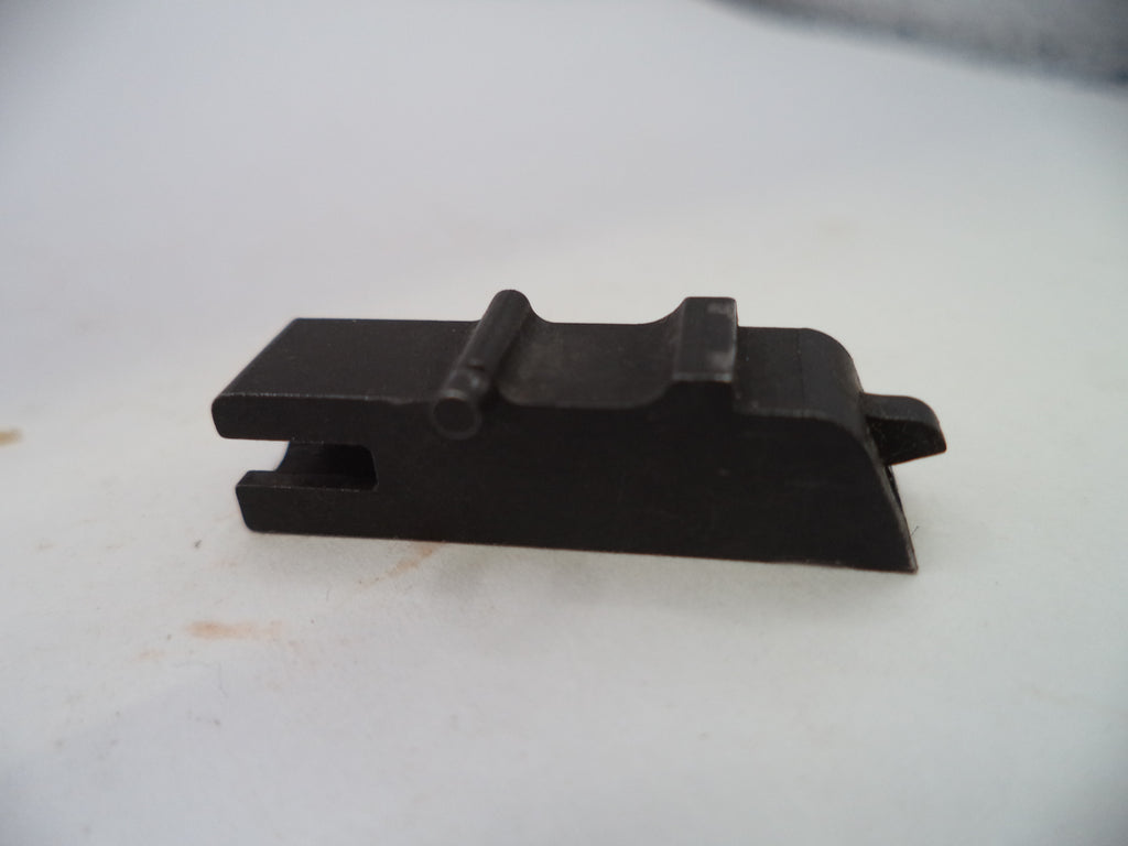A small black metal component, likely a firearm magazine or accessory part, photographed on a plain off-white surface.