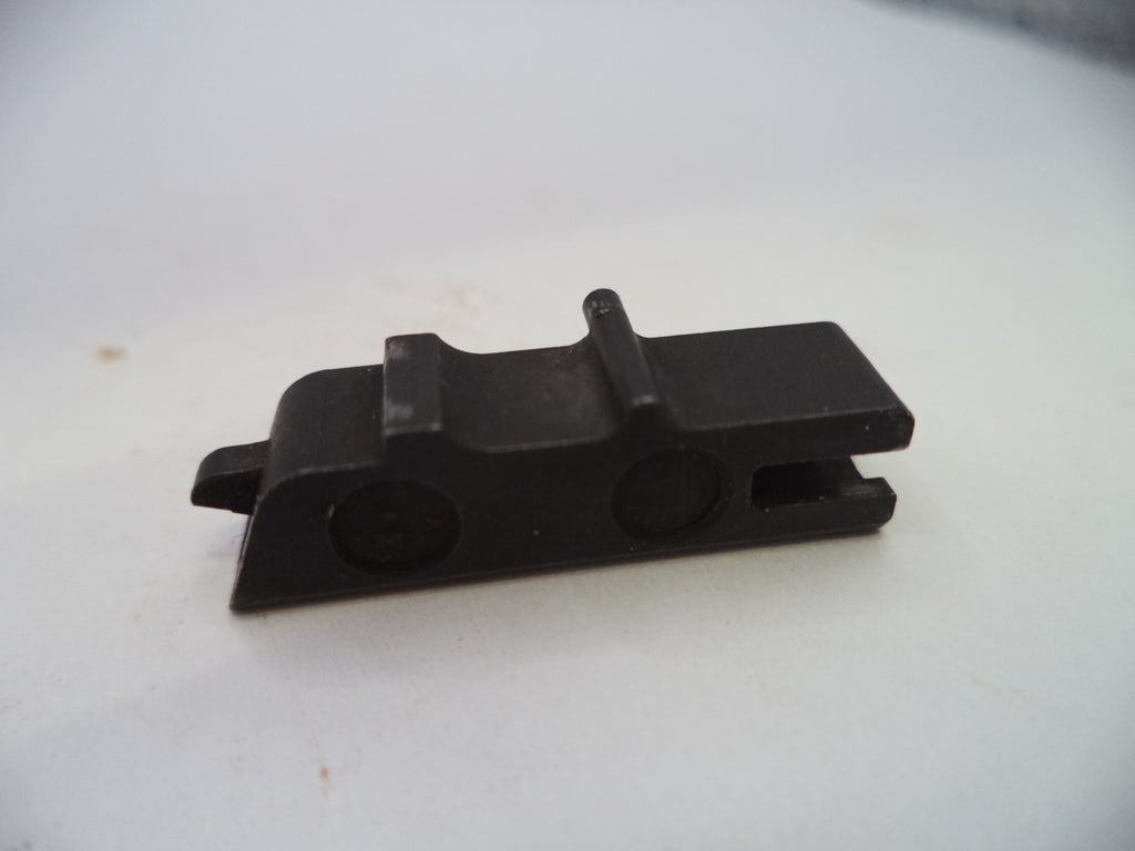 A small black plastic or metal hardware component with a rectangular body, two circular recesses, and a small protruding tab, photographed on a plain light background.