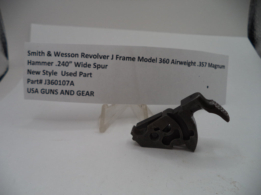 A used Smith & Wesson revolver J frame hammer part displayed on a clear stand in front of a white label card with product details.