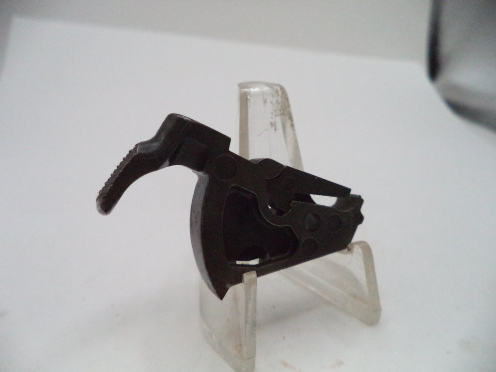 A black plastic trigger assembly for a firearm, displayed on a clear plastic stand against a white background.