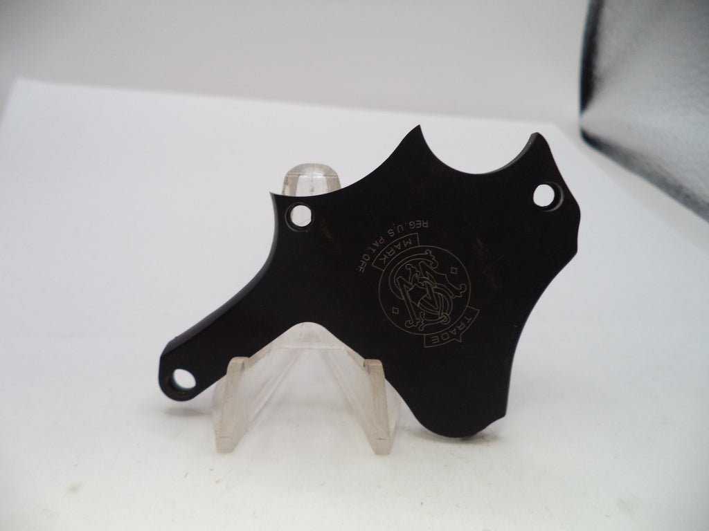 A black metal blade-shaped accessory with circular cutouts and an engraved crest logo, displayed on a clear plastic stand against a white background.