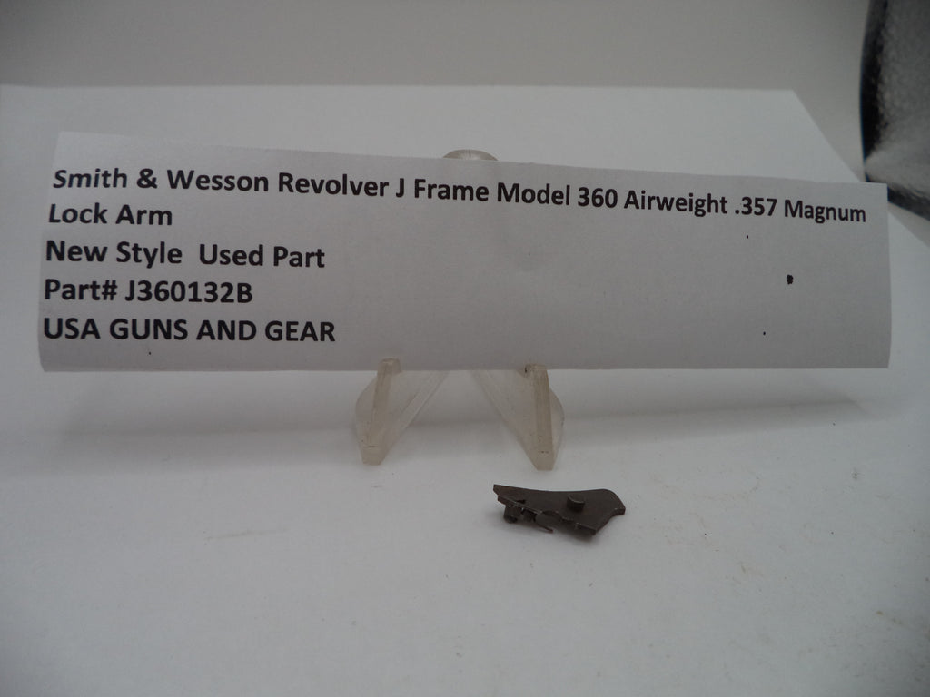 A small used metal lock arm part displayed on a clear plastic stand in front of a white paper label card. The label reads 'Smith & Wesson Revolver J Frame Model 360 Airweight .