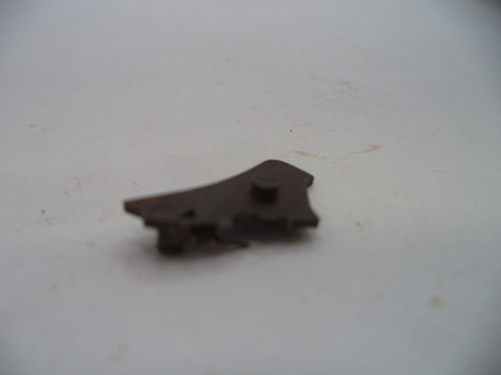 A small dark brown metal hardware component, possibly a latch or bracket, resting on a plain off-white surface.