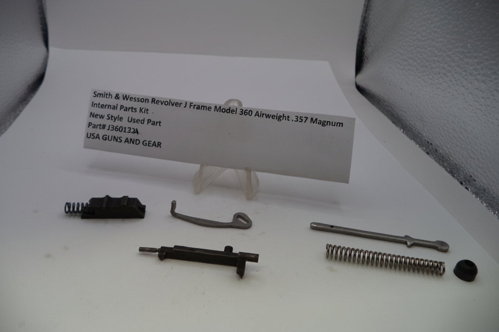Smith & Wesson Revolver J Frame Model 360 Airweight .357 Magnum internal parts kit components laid out on a white surface with a paper label card in the center.