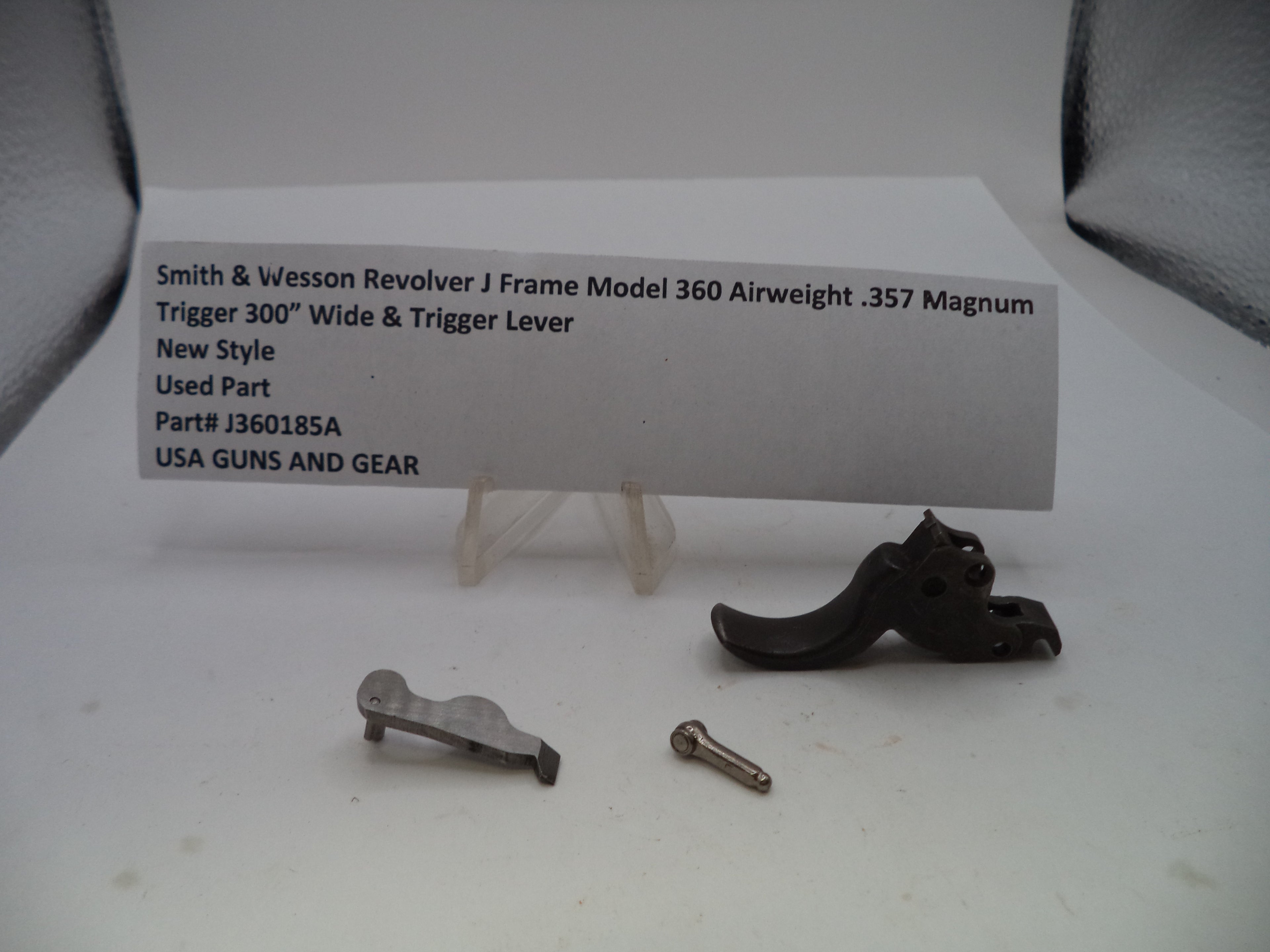 Smith & Wesson revolver J frame trigger lever part for a 360 airweight .357 Magnum, shown as a used part with its mounting screw and a small card displaying part details.