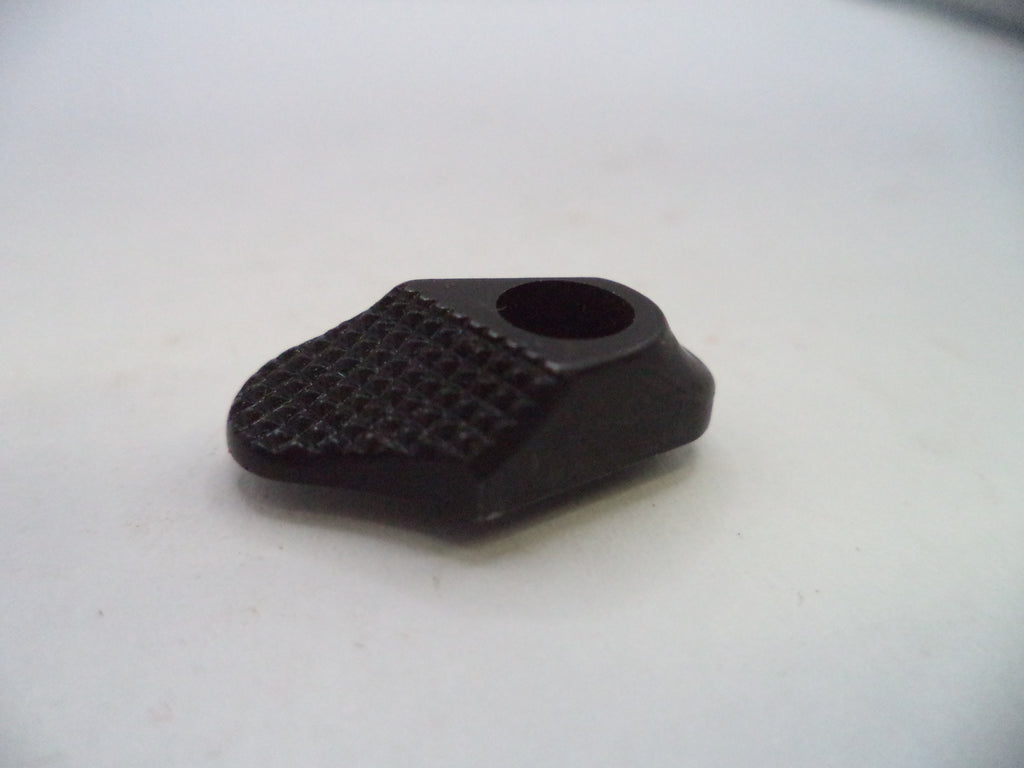 A small black plastic or rubber component with a textured grip surface and a circular hole, photographed on a plain light background.