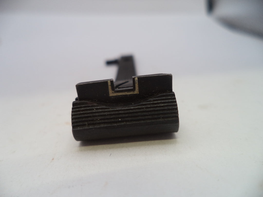 A close-up of a black metal rifle sight component with a ribbed cylindrical base and a flat top, photographed on a plain light background.