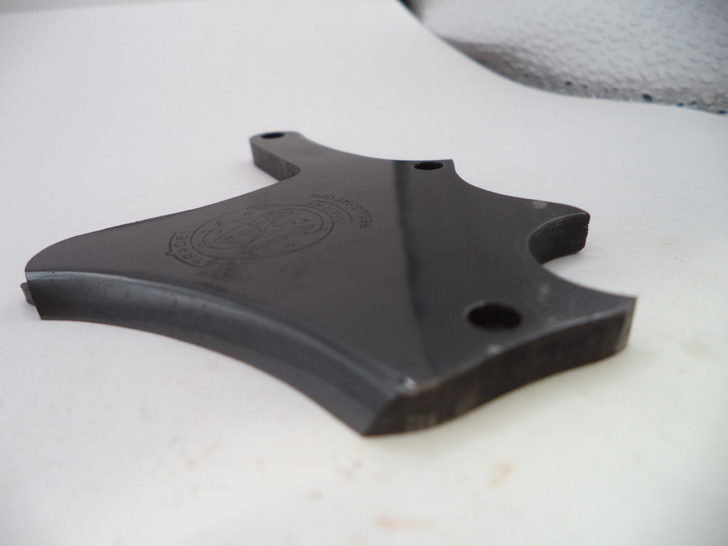 A black molded plastic replacement part with pre-drilled mounting holes, resting on a white surface.