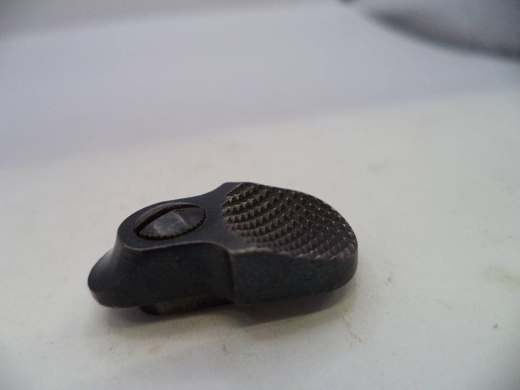 A small black textured metal hardware piece, possibly a latch or knob, resting on a light-colored surface.