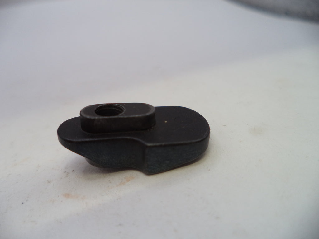 A small black plastic or metal hardware component with a circular opening, photographed on a plain off-white surface.