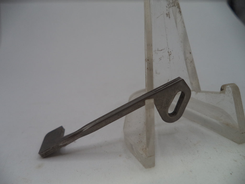 A small metal key-shaped tool with a looped end, displayed on a clear plastic stand against a plain light background.