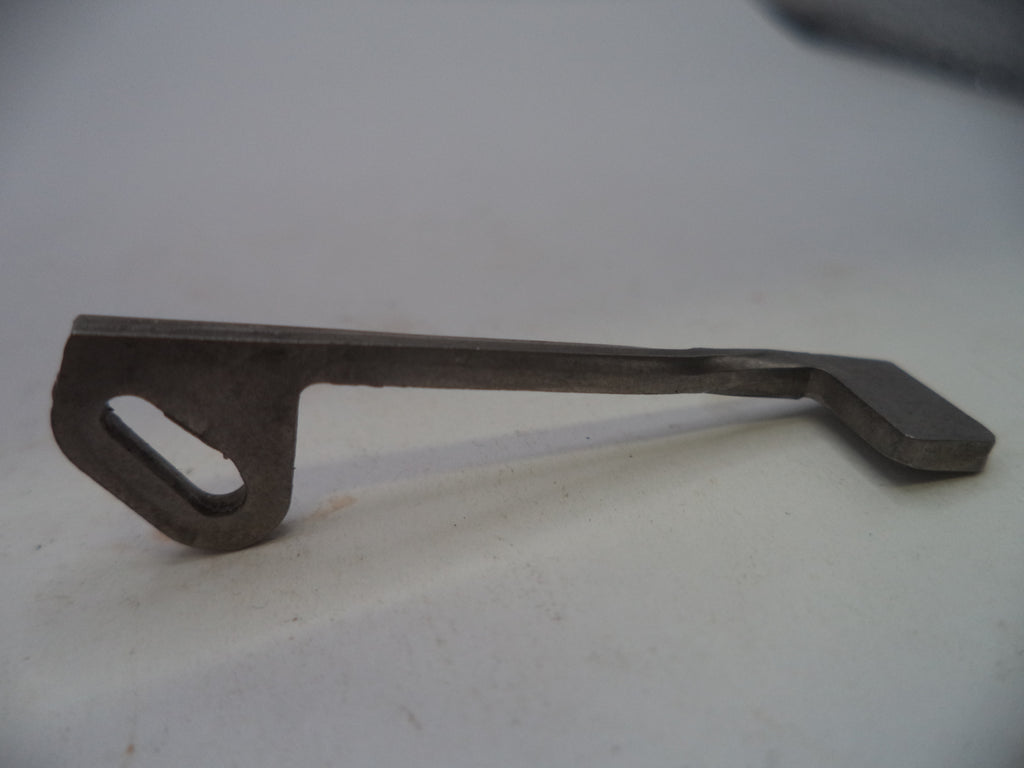 A small dark metal tool or hardware piece with a flat rectangular head and a looped handle, photographed on a plain light background.