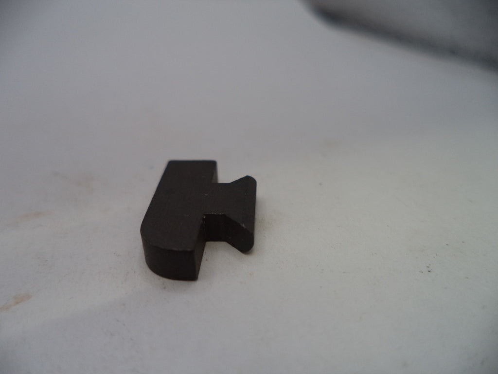A small black plastic or metal hardware piece with a bent tab, photographed on a plain off-white surface.