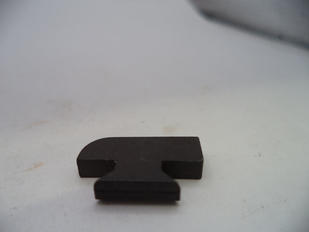 A small black plastic or rubber T-shaped block with a rounded top, resting on a light gray surface.